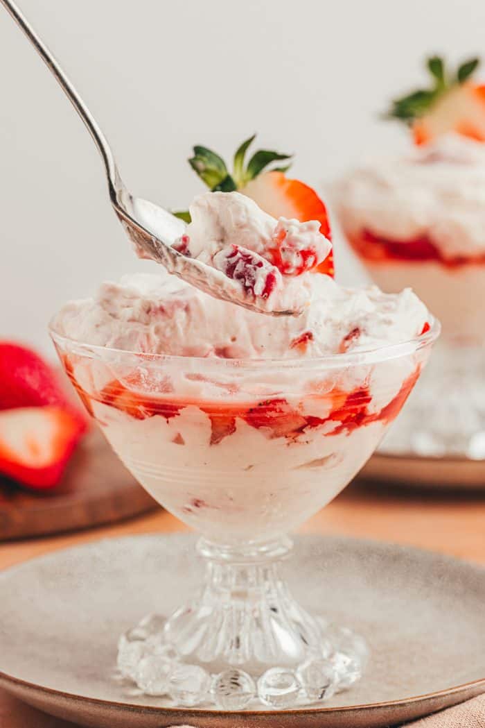 A glass parfait dish with homemade strawberry fool.