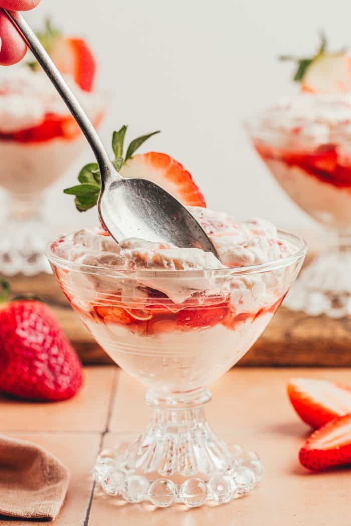 A glass parfait dish with homemade strawberry fool.