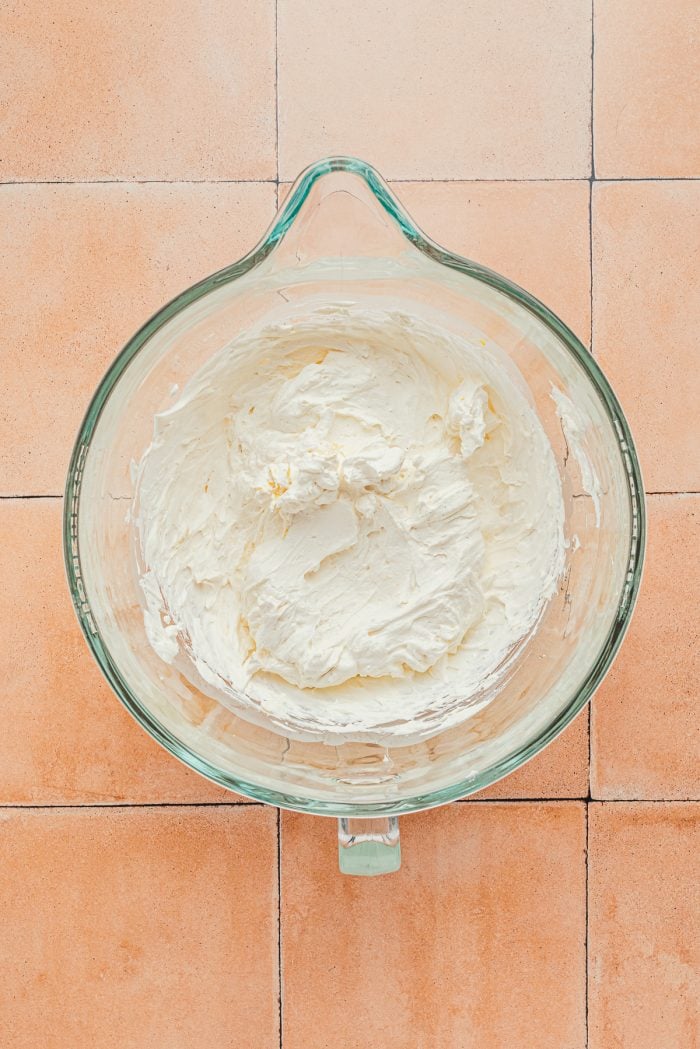 Whipped heavy cream and Mascarpone cheese in a glass bowl.