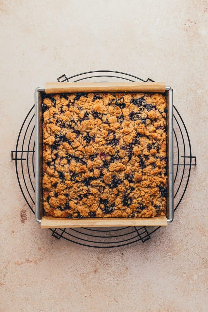A baked blueberry crumb cake on a cooling rack.