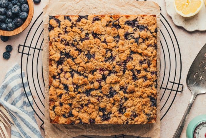 A baked blueberry crumb cake removed from the pan on a cooling rack.