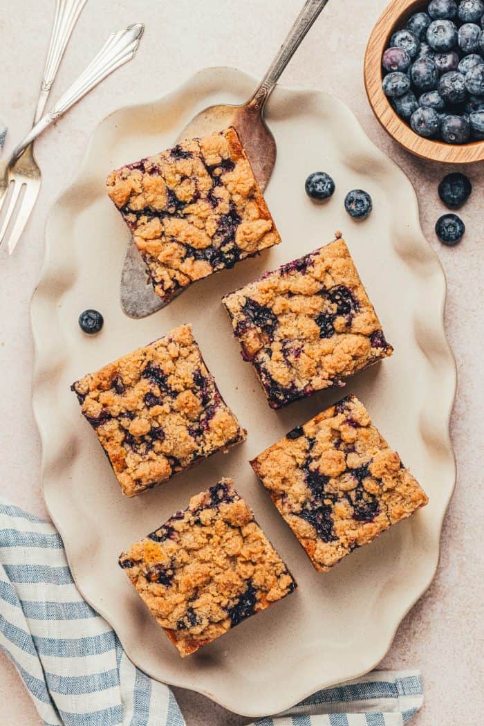 Five slices of blueberry crumb cake on a platter.