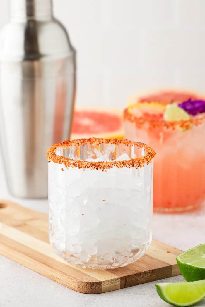 Filling a glass that is rimmed with Tajin with ice.