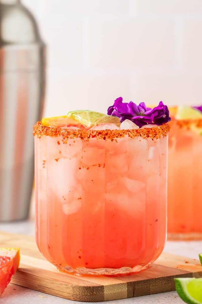 A glass rimmed with Tajin and filled with Guava Paloma.