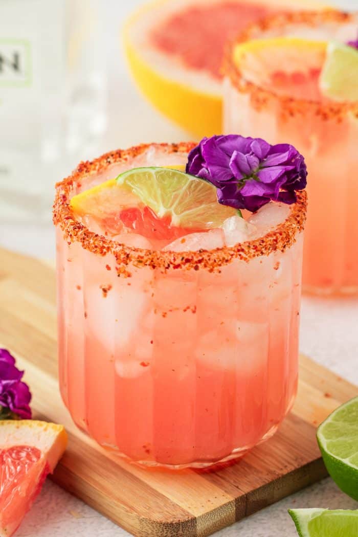 Two Guava Paloma in glasses with flower garnishes.