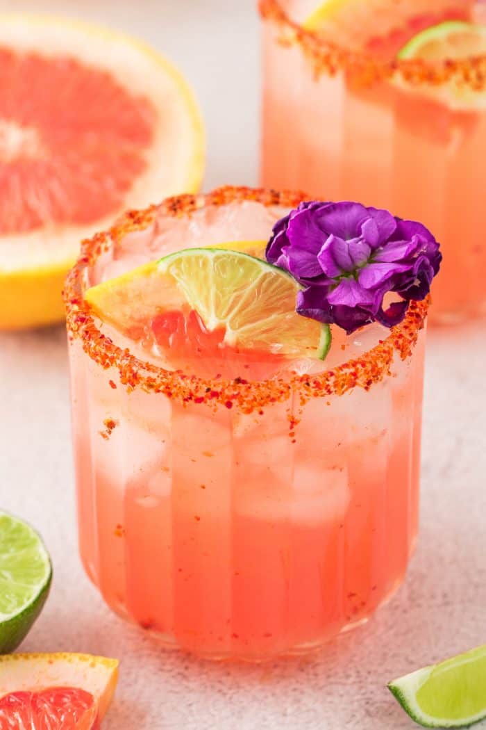 Two Guava Paloma in glasses with flower garnishes.