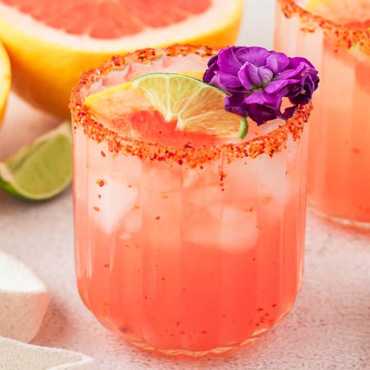 Two Guava Paloma in glasses with flower garnishes.