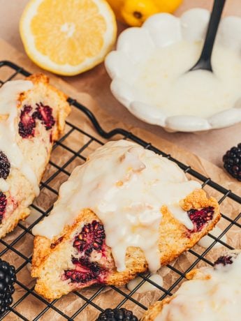 Glazed blackberry scones on a cooling rack.