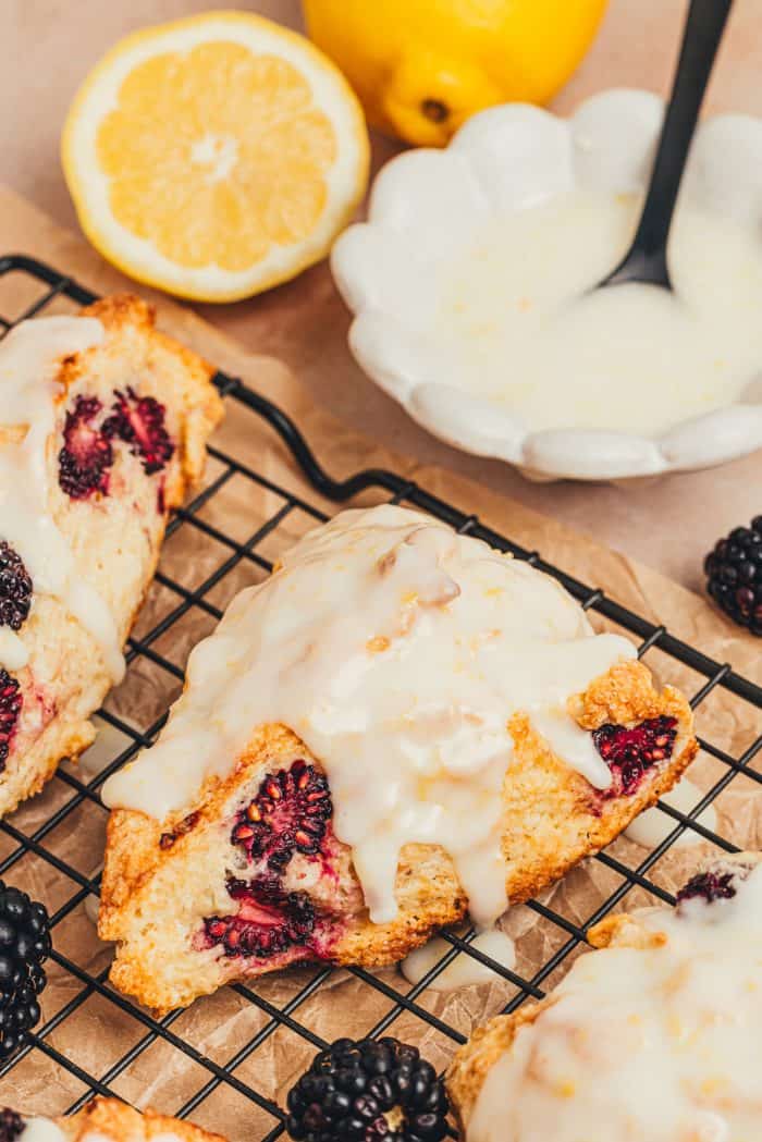 Glazed blackberry scones on a cooling rack.