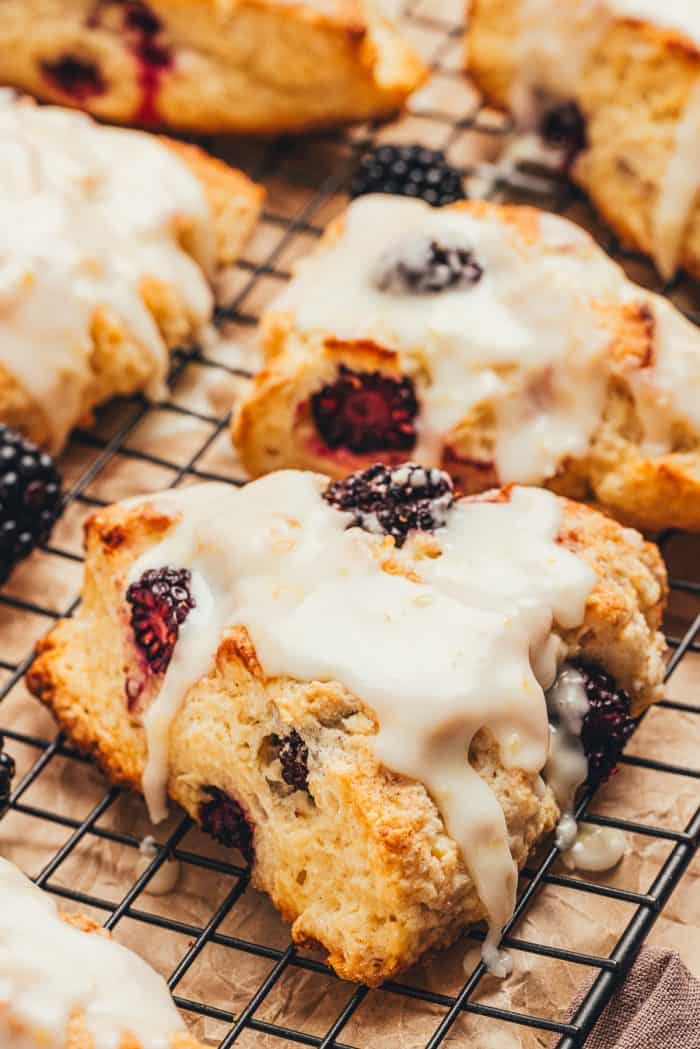 Glazed blackberry scones on a cooling rack.
