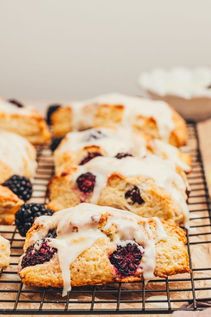 Glazed blackberry scones on a cooling rack.
