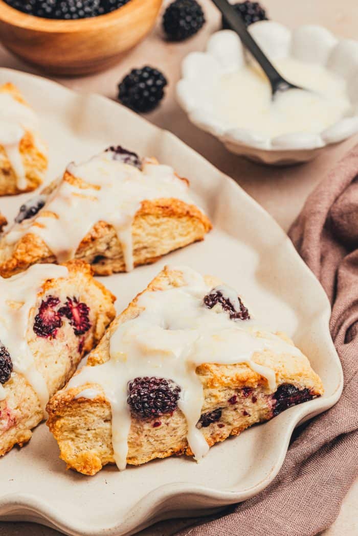 Glazed blackberry scones on a platter.