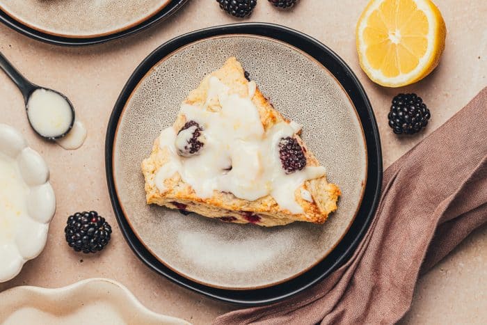 A plate with a glazed blackberry scone.