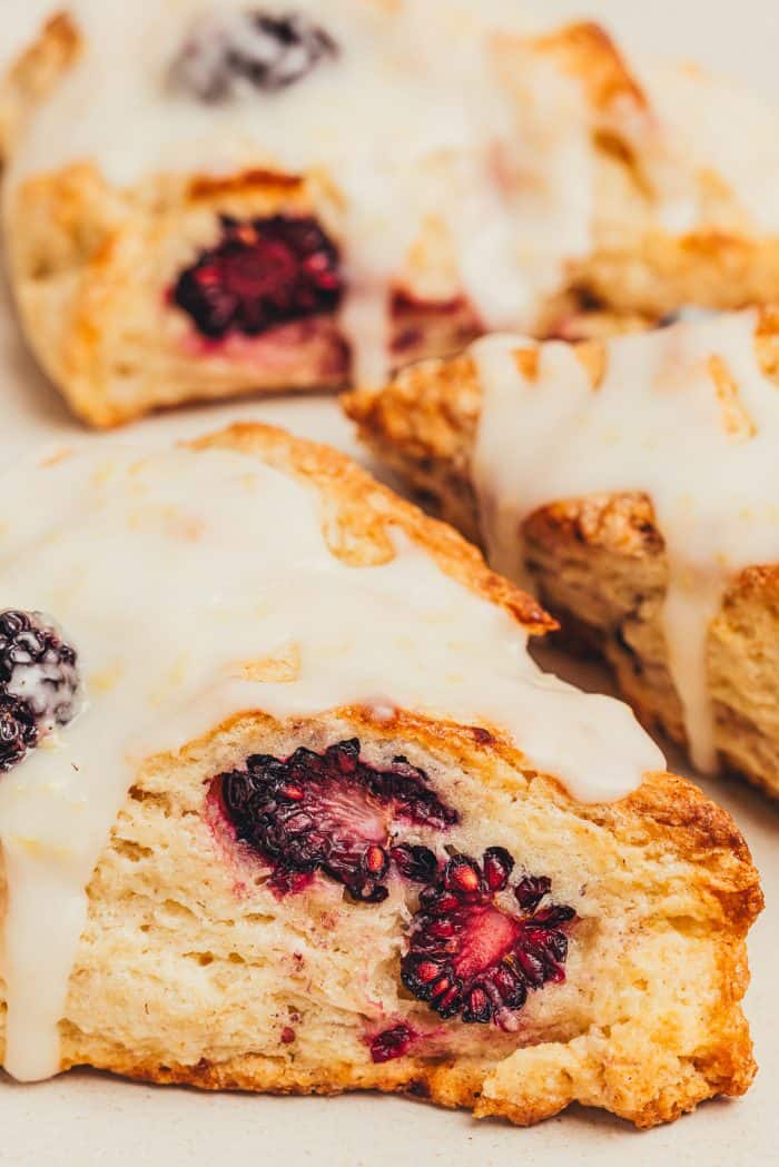 Baked blackberry scones with a glaze over them.