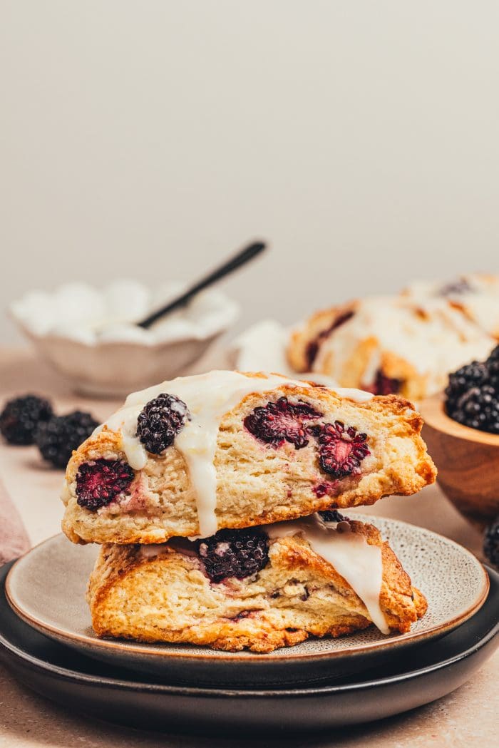 Two blackberry scones stacked on a plate.