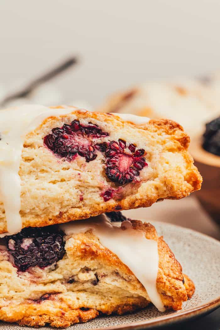 Two blackberry scones stacked on a plate.