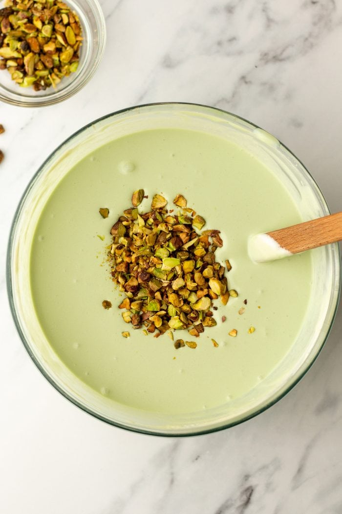 A glass bowl with the pistachio mixture and chopped pistachios. 