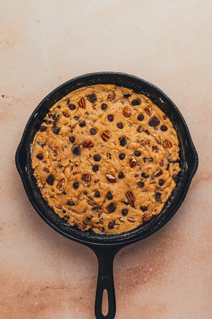Raw chocolate chip cookie dough added to a greased skillet.