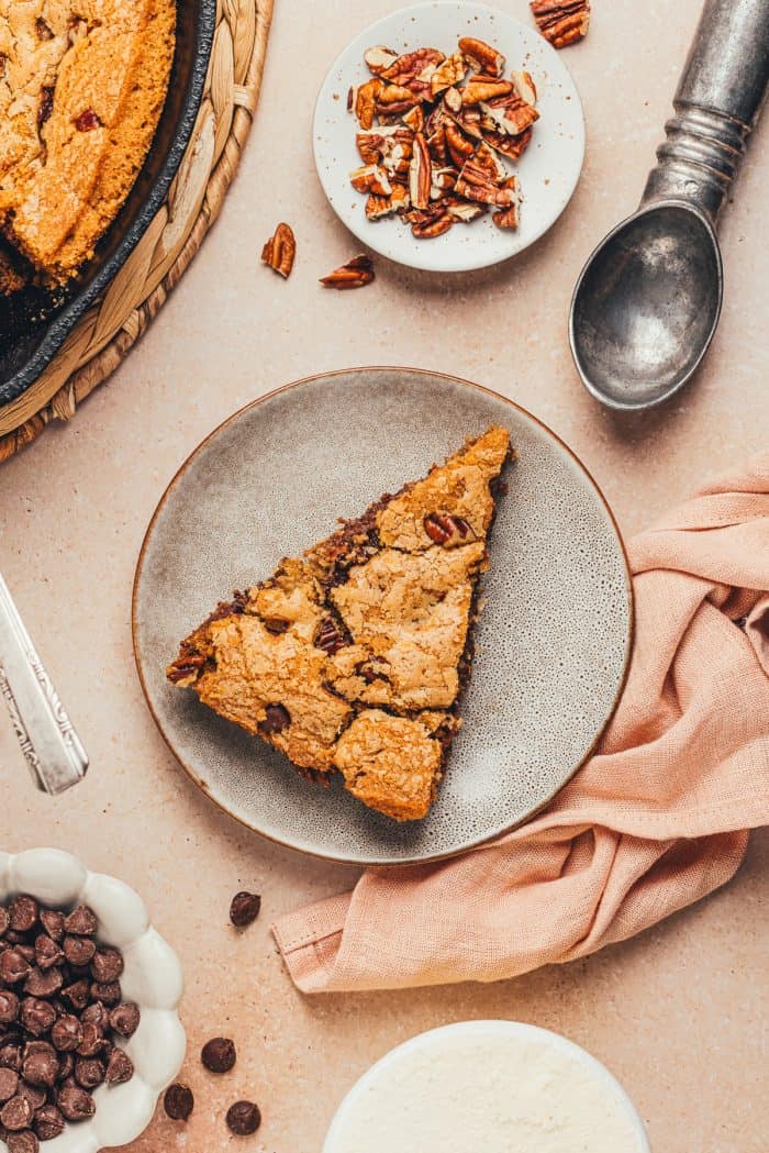 A plate with a slice of brown butter pecan chocolate chip skillet cookie.
