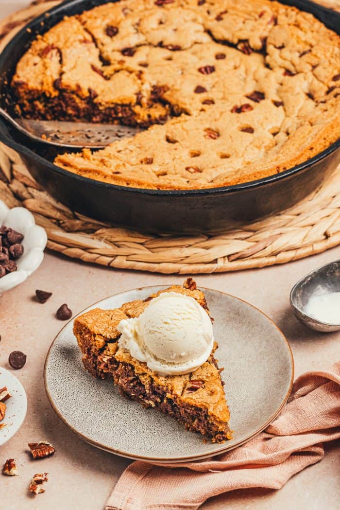 A plate with a slice of brown butter pecan chocolate chip skillet cookie.