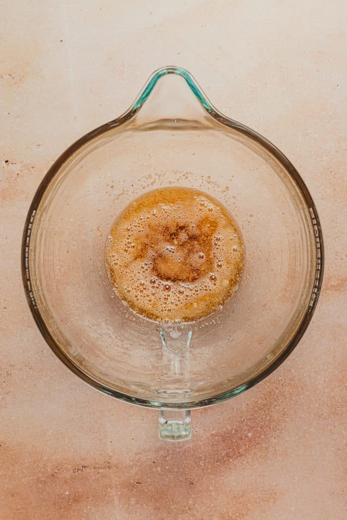 A glass mixing bowl with brown butter.