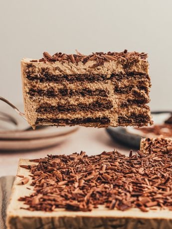 A slice of the chocolate icebox cake on a spatula being lifted in the air.
