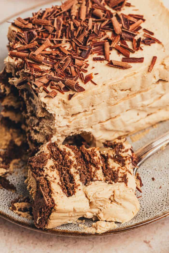 A slice of the chocolate icebox cake on a plate with a bite taken out of it.