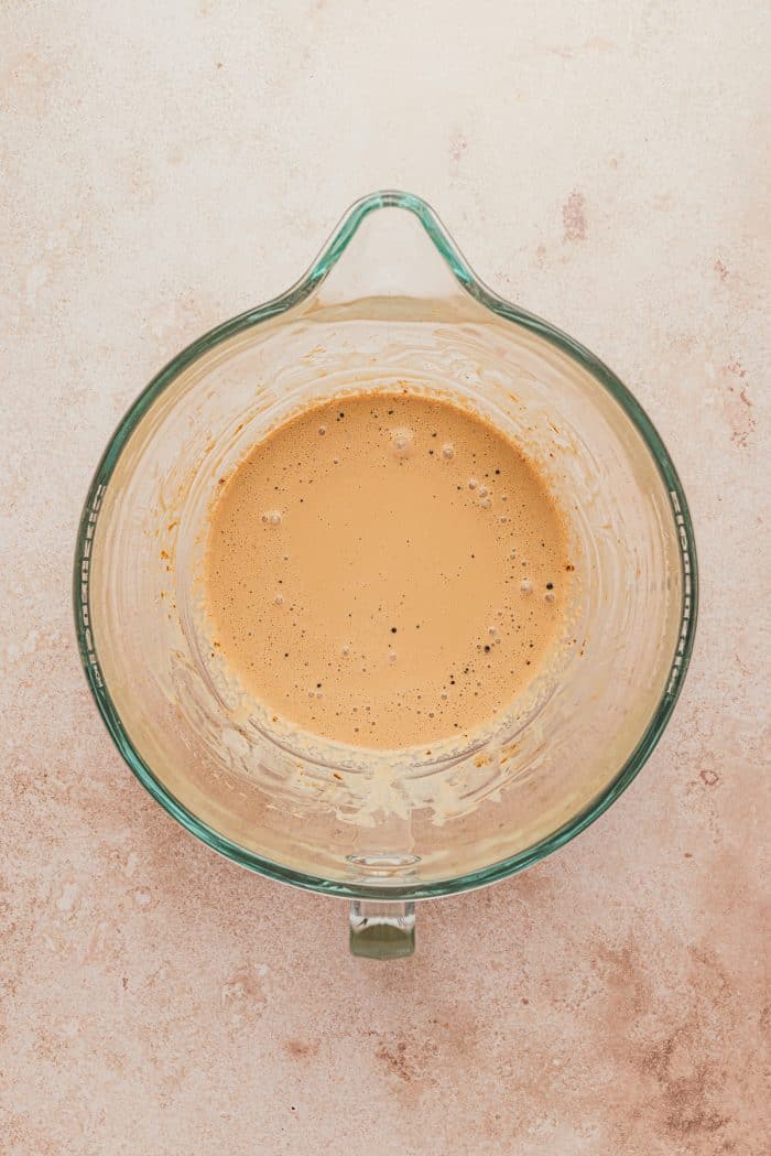 Whipping cream and espresso powder in a glass bowl.