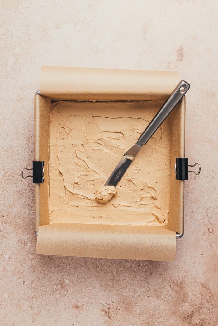 A thin layer of espresso cream spread over the parchment paper.