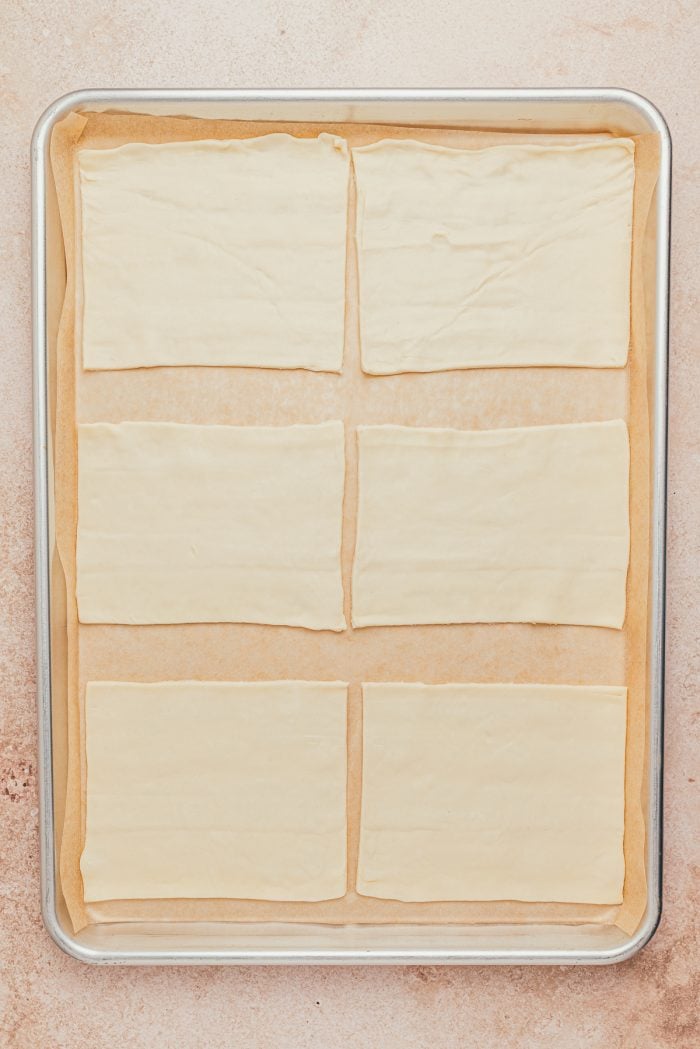 Raw puff pastry on a baking sheet.