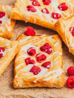 Homemade raspberry lemon cream cheese danishes stacked on each other.