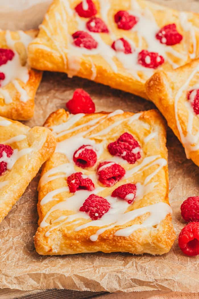 Homemade raspberry lemon cream cheese danishes stacked on each other.