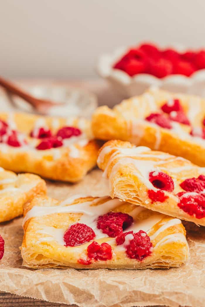 Homemade raspberry lemon cream cheese danishes stacked on each other.