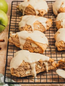 Apple cinnamon scones on a black cooling rack.