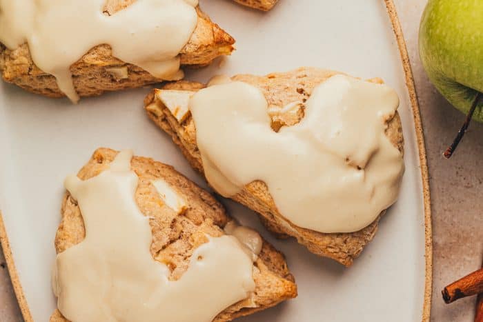 Three apple & cinnamon scones on a plate.