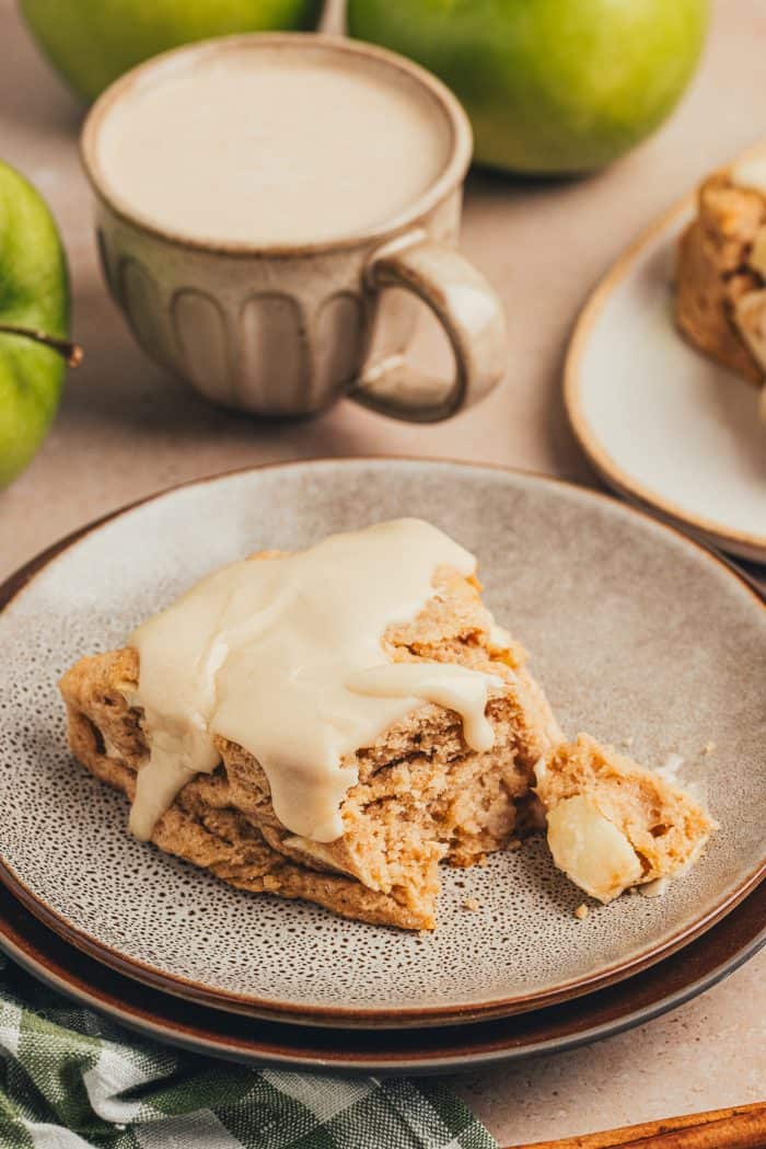 A cinnamon apple scone on a plate with a plaid green towel.