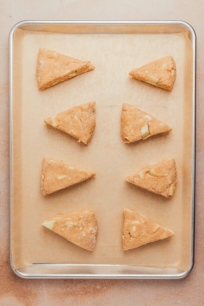 A baking tray with unbaked cinnamon apple scones. 