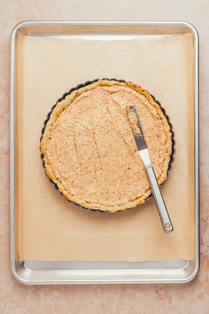 The baked tart shell with the tart filling spread over it.