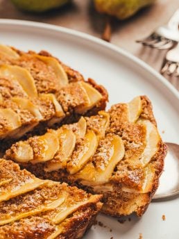 An overhead view of the pear frangipane tart with a slice being removed.