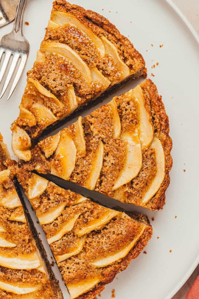An overhead view of the pear frangipane tart with it cut into slices. 