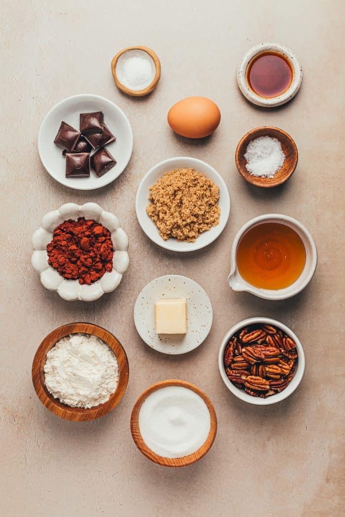 A variety of bowls and plates with the ingredients to make pecan pie brownies.