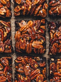 Pecan Pie Brownies are sliced and displayed on parchment paper.