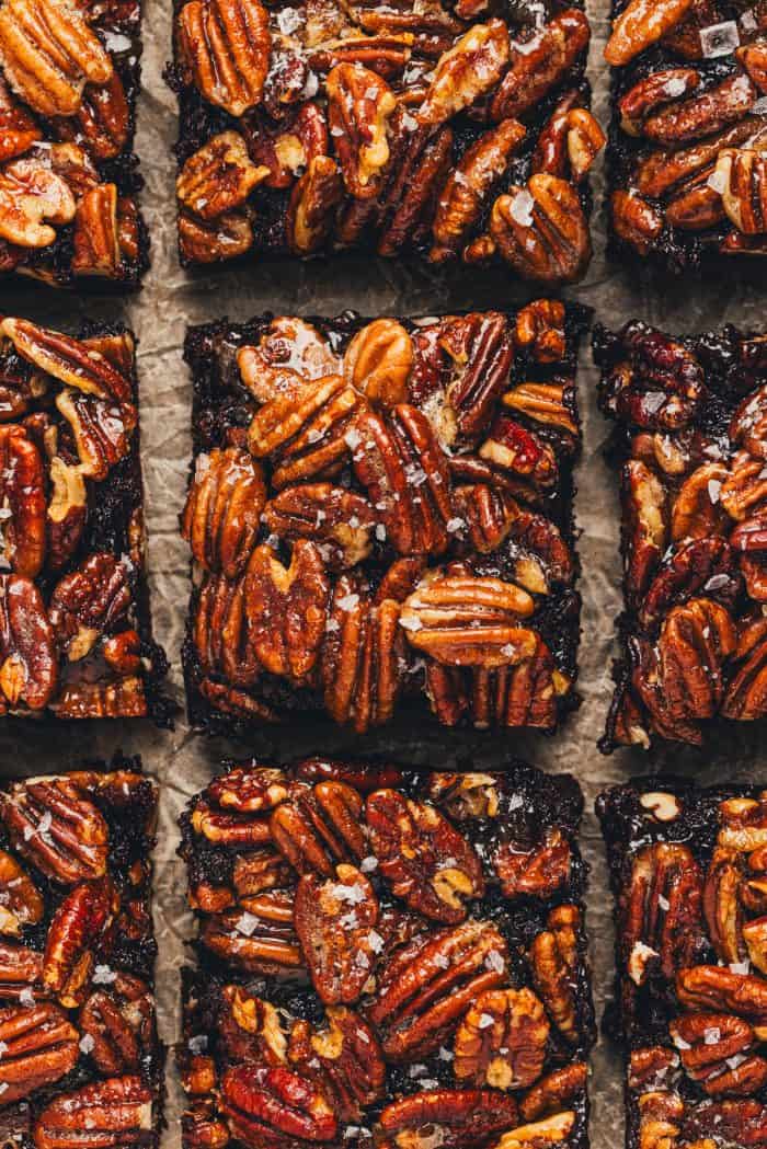 Pecan Pie Brownies are sliced and displayed on parchment paper.