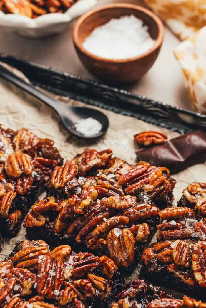 A few pecan pie brownies are sliced on a baking sheet with parchment paper.