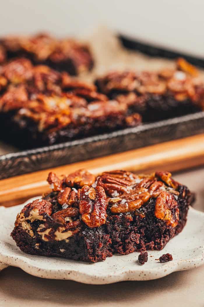 Two pecan pie brownies are on a white plate.