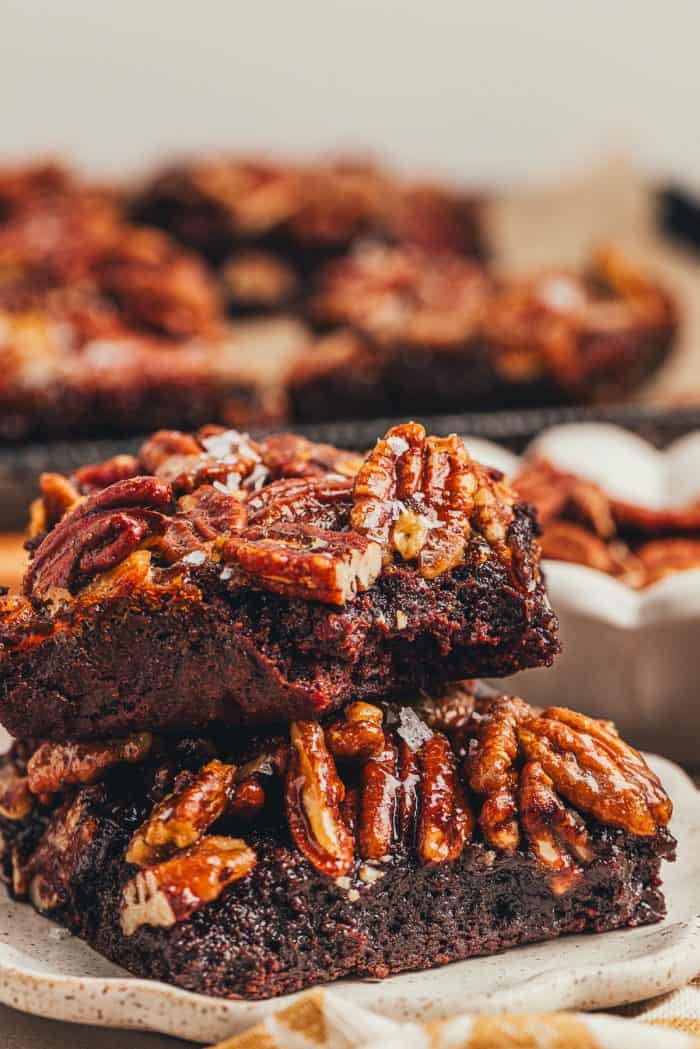 Two pecan pie brownies are on a white plate.