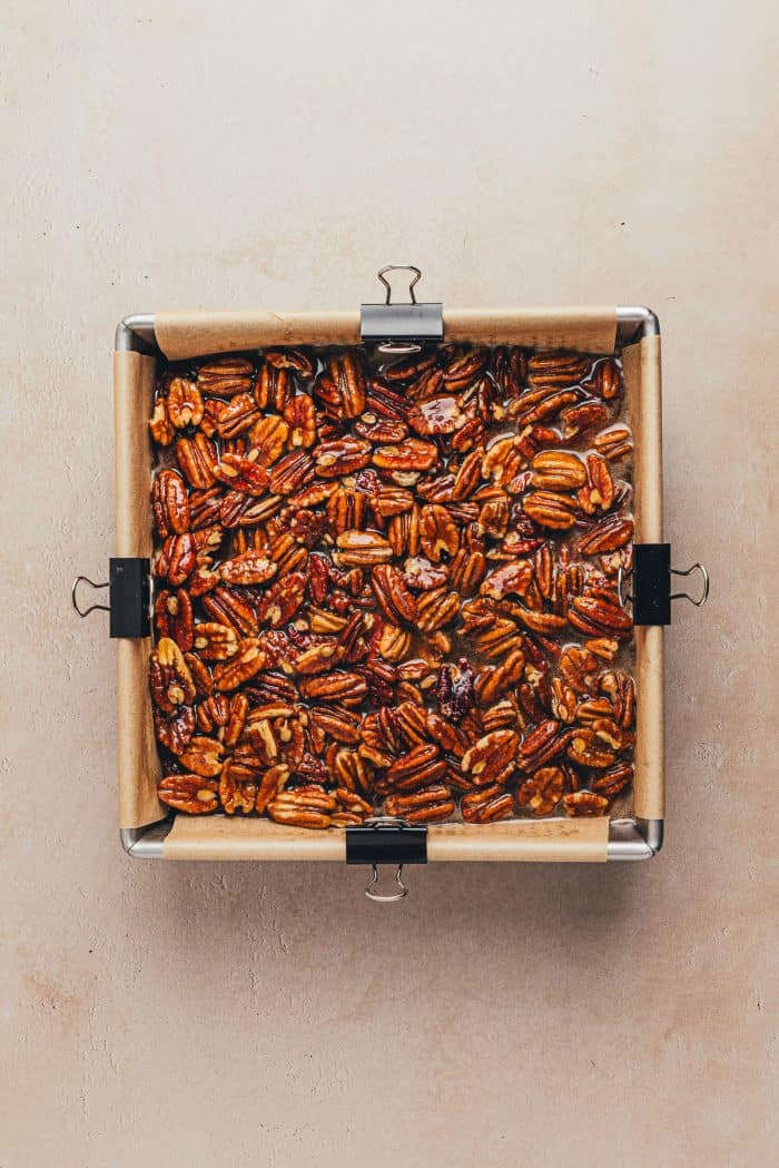 The pecan mixture poured over the baked brownies.