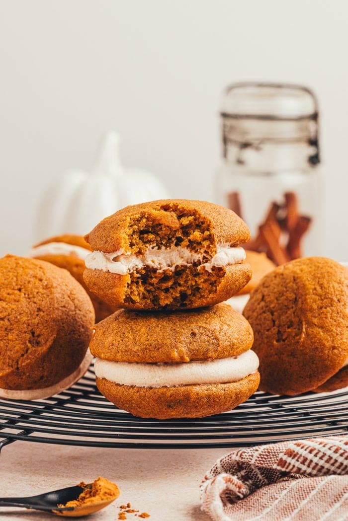 Pumpkin whoopie pies on a round cooling rack.