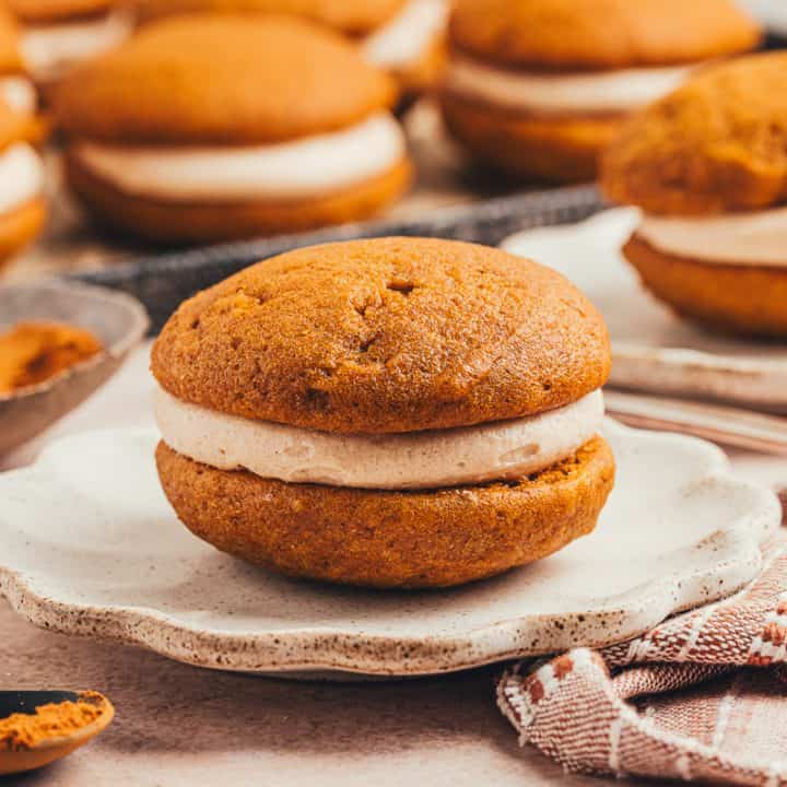 A pumpkin whoopie pie on a plate.