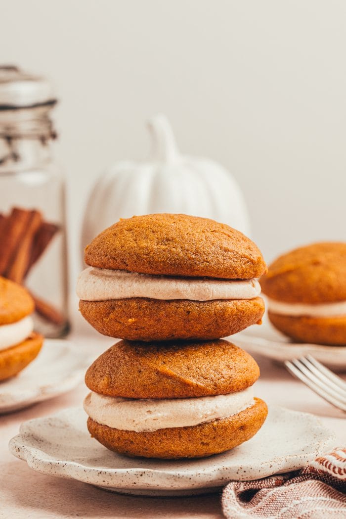 A stack of pumpkin whoopie pies on a plate.